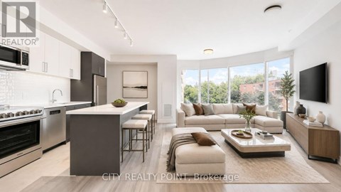 A modern kitchen with a breakfast bar and a living room with a couch and a coffee table.