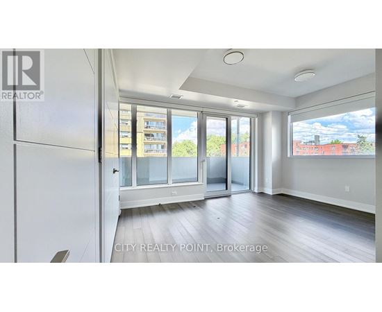 A spacious room with a view of the city through large windows.