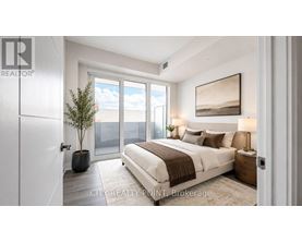 A bedroom with a large bed, a potted plant, and a painting on the wall.