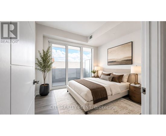 A bedroom with a large bed, a potted plant, and a painting on the wall.