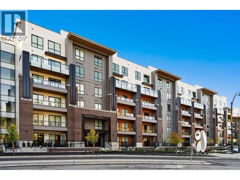 A modern apartment building with balconies and a clear blue sky.