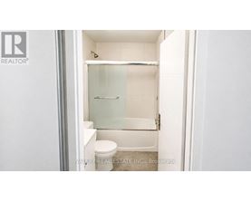 A small white bathroom with a toilet and a walk-in shower.
