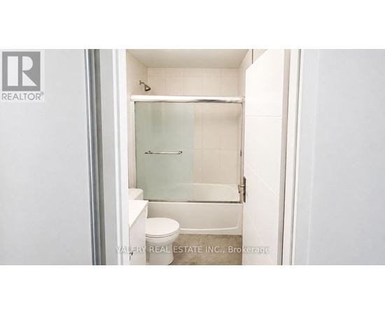 A small white bathroom with a toilet and a walk-in shower.