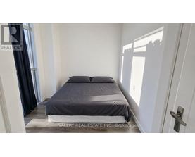 A bedroom with a bed, a rug, and a door.