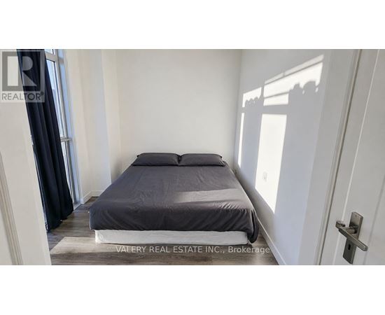 A bedroom with a bed, a rug, and a door.