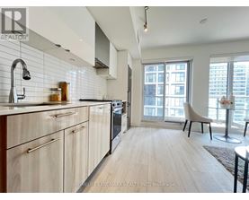 A kitchen with wooden cabinets and a large window.