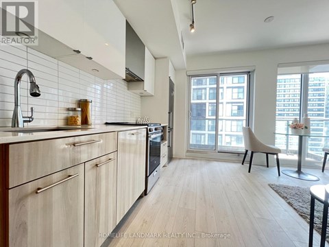 A kitchen with wooden cabinets and a large window.