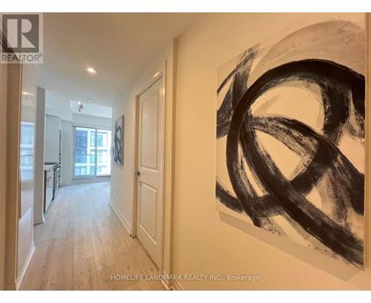 A hallway with a large painting on the wall and a door on the left.