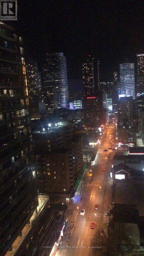A nighttime city street with cars and buildings.