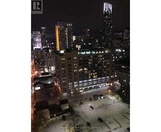 A cityscape at night with a tall building in the background.