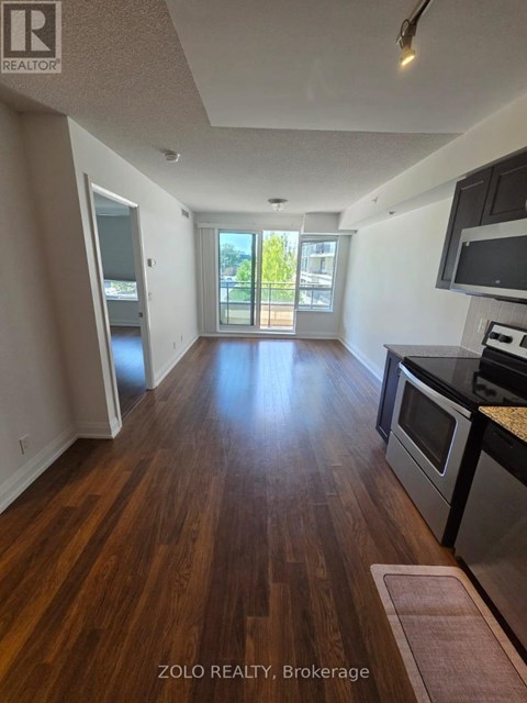 A kitchen with wood floors and a view of a balcony.