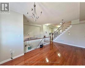 A spacious living room with hardwood floors and a staircase leading to the upper level.