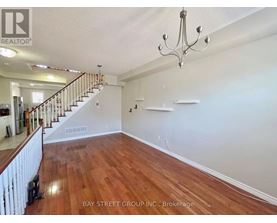 A spacious room with wooden floors and a chandelier.