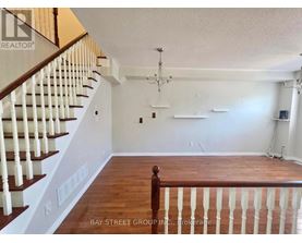 A spacious room with a staircase and a chandelier.