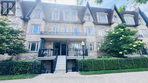 A large, multi-level house with a stone facade and a black metal fence.