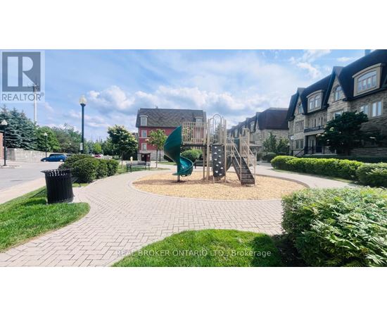 A playground with a slide and a climbing frame in the middle of a paved area.