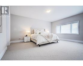 A bedroom with a bed, nightstand, and window.