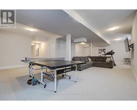 A spacious room with a JOOLA table tennis table and a couch.