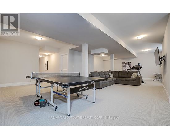 A spacious room with a JOOLA table tennis table and a couch.