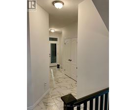 A hallway with marble flooring and white walls.