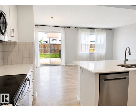A kitchen with white cabinets and a stainless steel dishwasher.