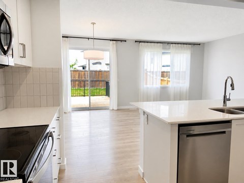A kitchen with white cabinets and a stainless steel dishwasher.