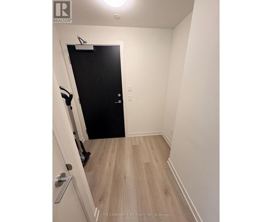 A hallway with a black door and a white door with a silver handle.