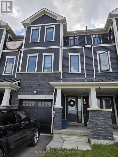 A black car is parked in front of a two-story house.