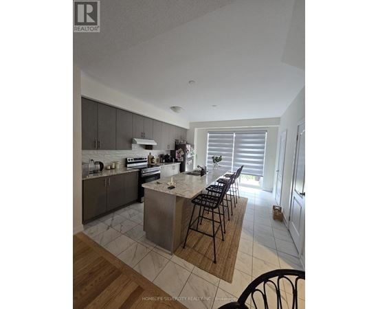 A kitchen with a center island and bar stools.