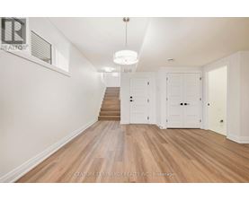 A spacious room with wooden floors and white walls.