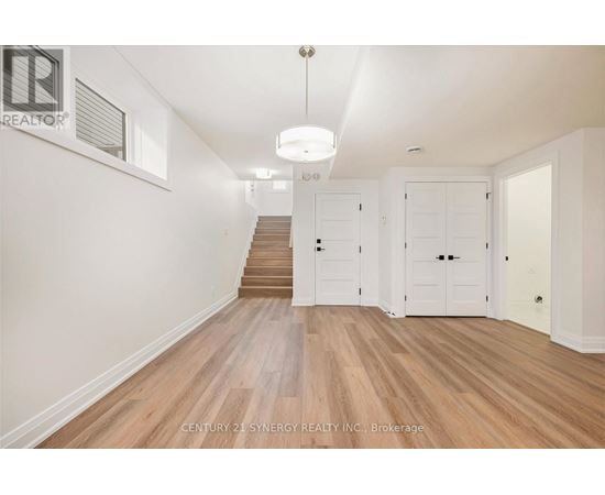 A spacious room with wooden floors and white walls.