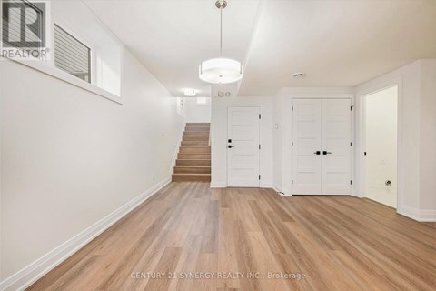 A spacious room with wooden floors and white walls.