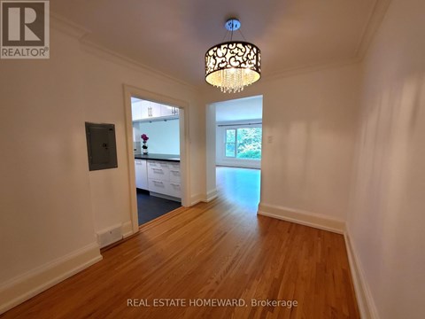 A well-lit room with wooden floors and a chandelier.