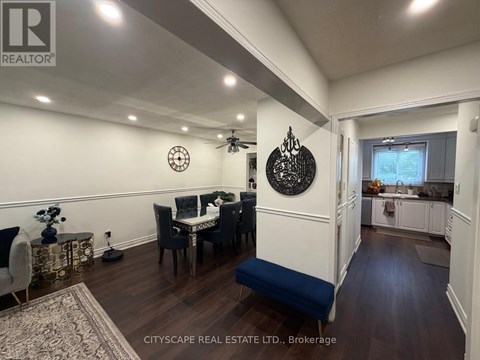 A dining room with a table set for four and a kitchen area in the background.