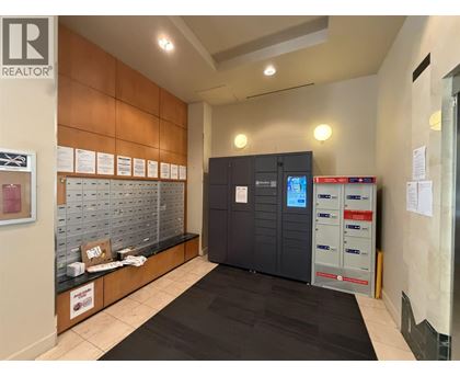 A realtor office with a black carpet and a brown wall.