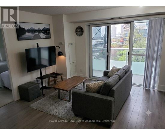 A living room with a couch, a coffee table, and a television.