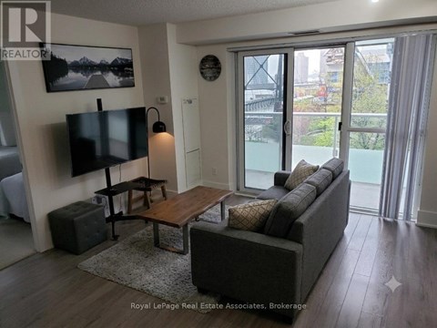 A living room with a couch, a coffee table, and a television.