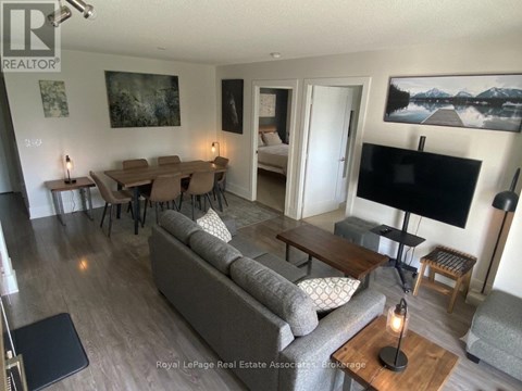 A living room with a grey couch and a black television.