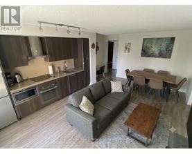 A living room with a grey couch and a wooden coffee table.