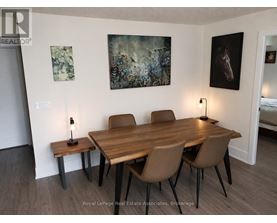 A dining room with a wooden table and chairs.