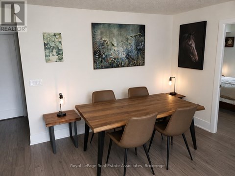 A dining room with a wooden table and chairs.