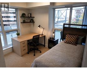 A bedroom with a bed, desk, and chair.