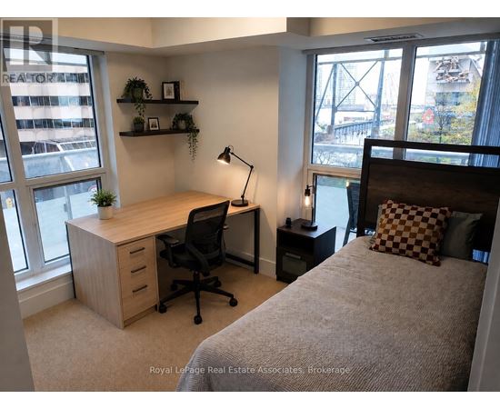 A bedroom with a bed, desk, and chair.