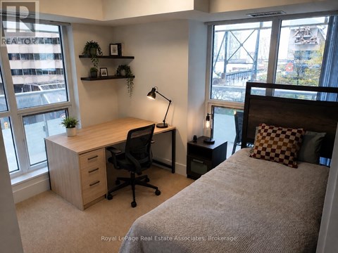 A bedroom with a bed, desk, and chair.