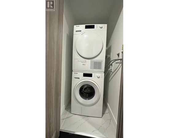 A white dryer and washer in a small laundry room.
