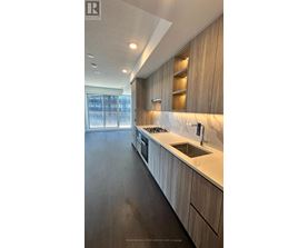 A modern kitchen with wooden cabinets and a marble countertop.