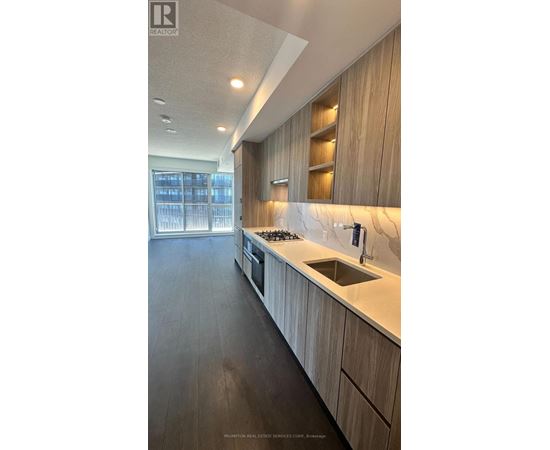 A modern kitchen with wooden cabinets and a marble countertop.