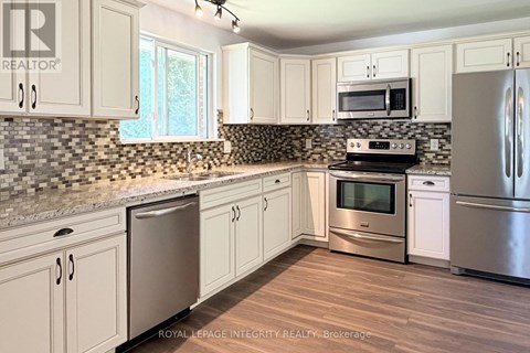 A kitchen with white cabinets and stainless steel appliances.