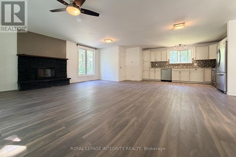 A spacious room with wooden flooring and a ceiling fan.