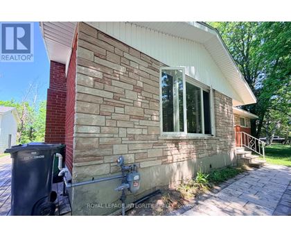A house with a brick wall and a window is for sale.